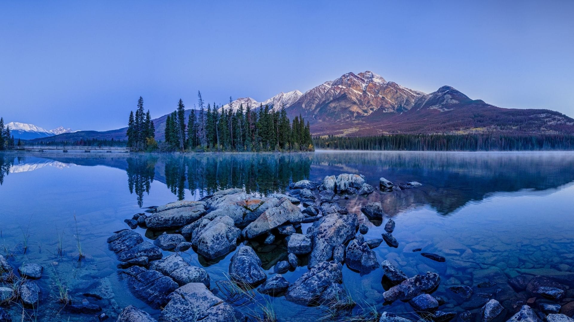 Weite Berglandschaft mit See und Wäldern in Kanada als Symbol für die Provinzen und Territorien